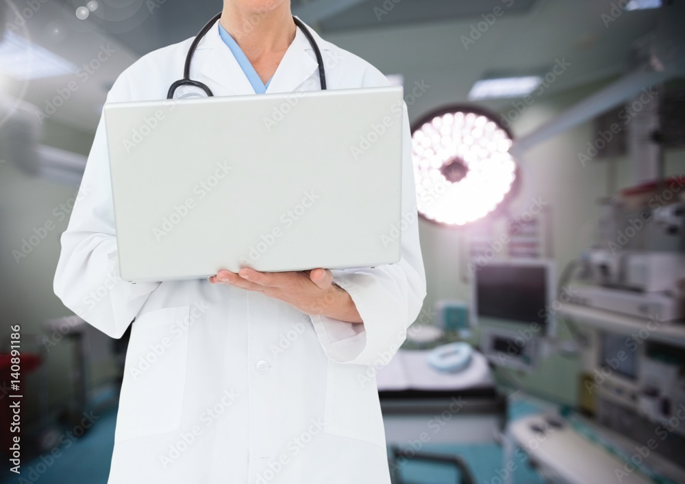 医生在后台使用笔记本电脑对抗手术室