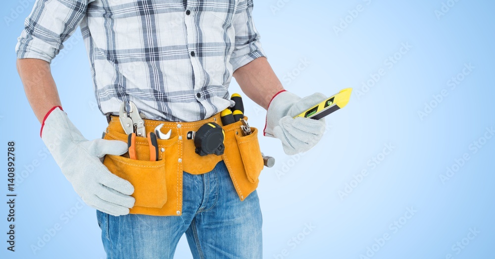 Handy man standing with tools against blue background