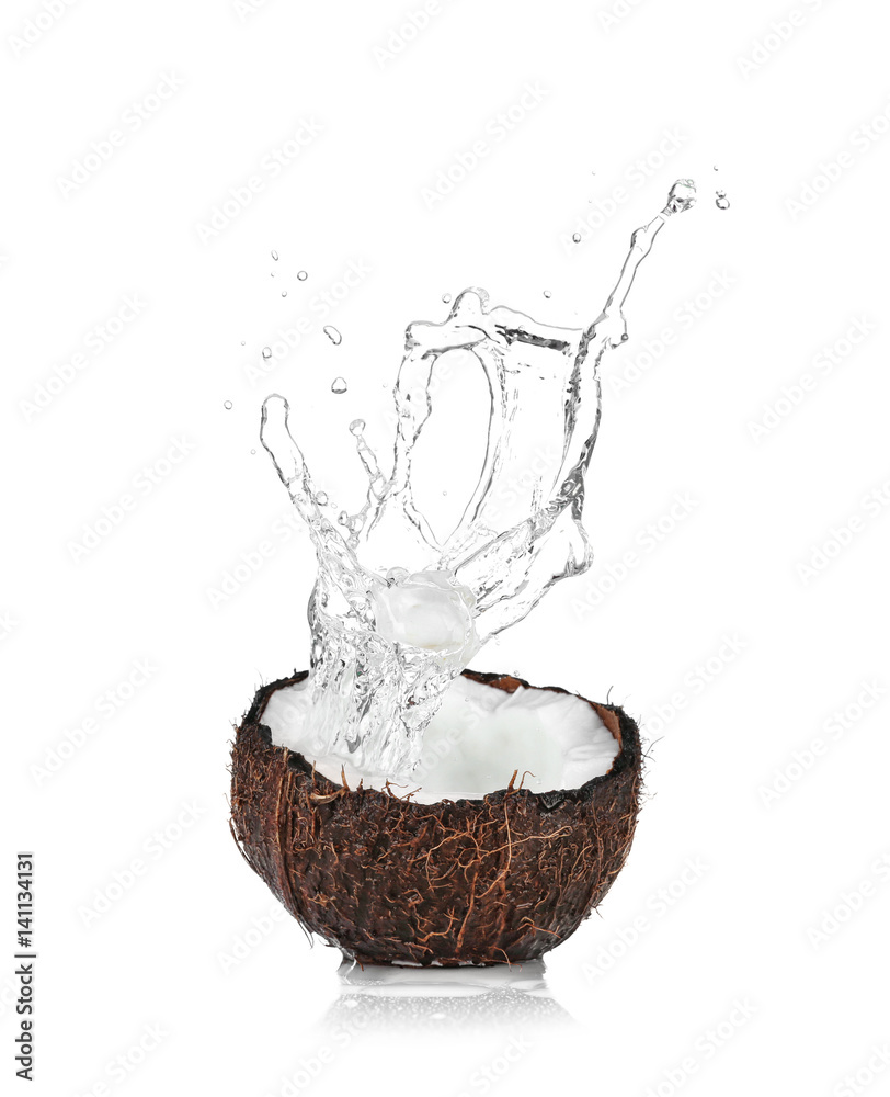 Cracked coconut with splashes of water on white background