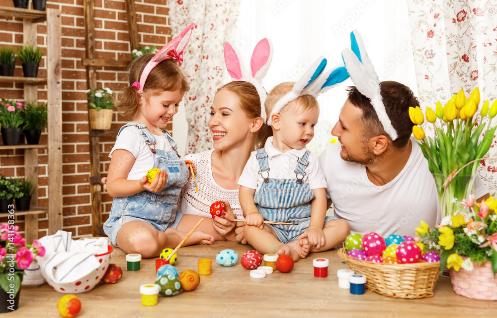 复活节快乐！家庭母亲、父亲和孩子们为节日画鸡蛋。