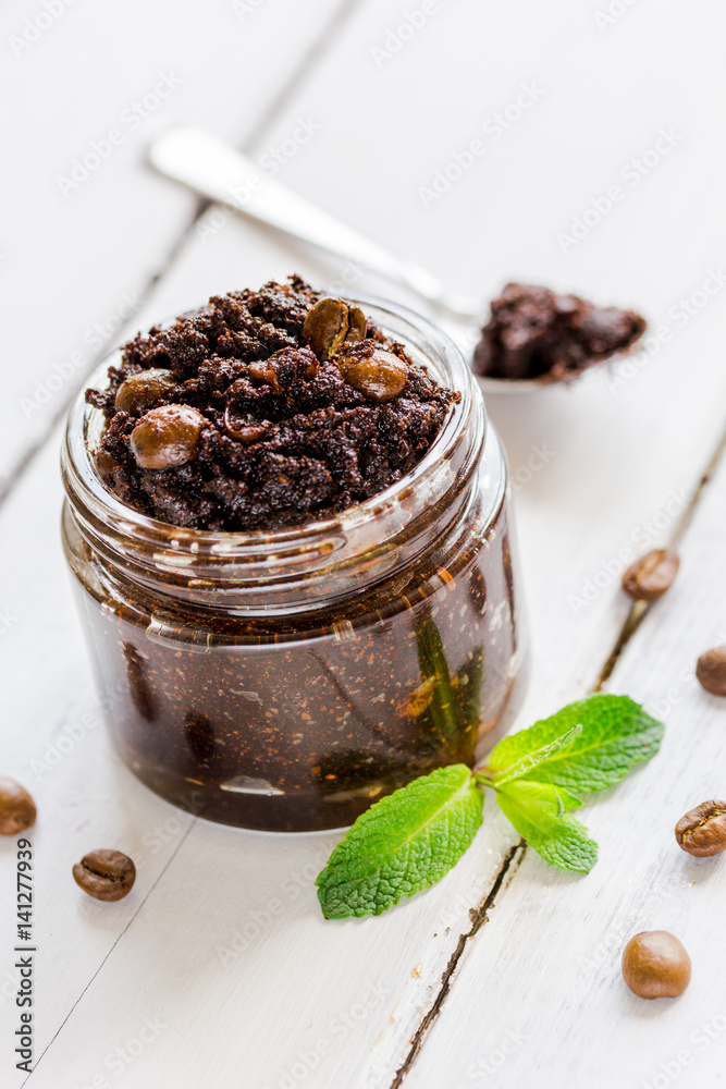 Homemade cosmetics with scrub and coffee beans on desk background
