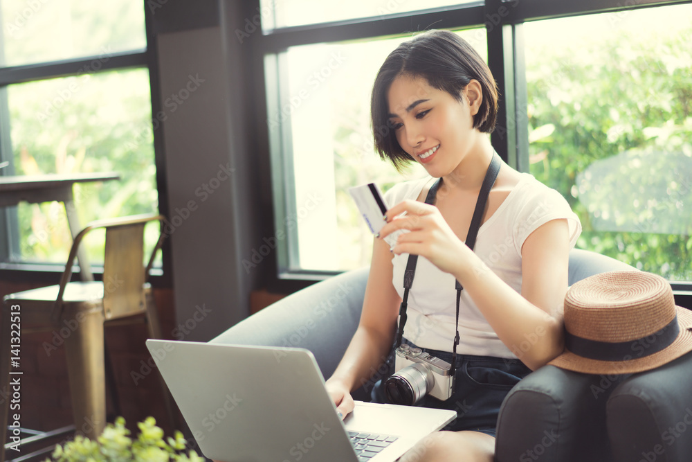 Woman asian travelers she shopping online or in flight. by credit card at a coffee shop..