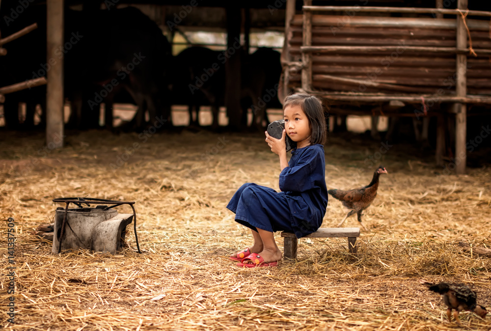 亚洲孩子在农村听广播。