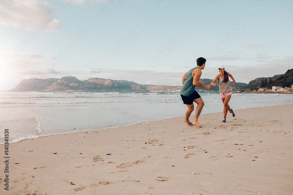 健康的年轻情侣在海滩上玩耍