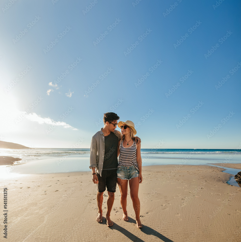 浪漫的年轻情侣走在海边