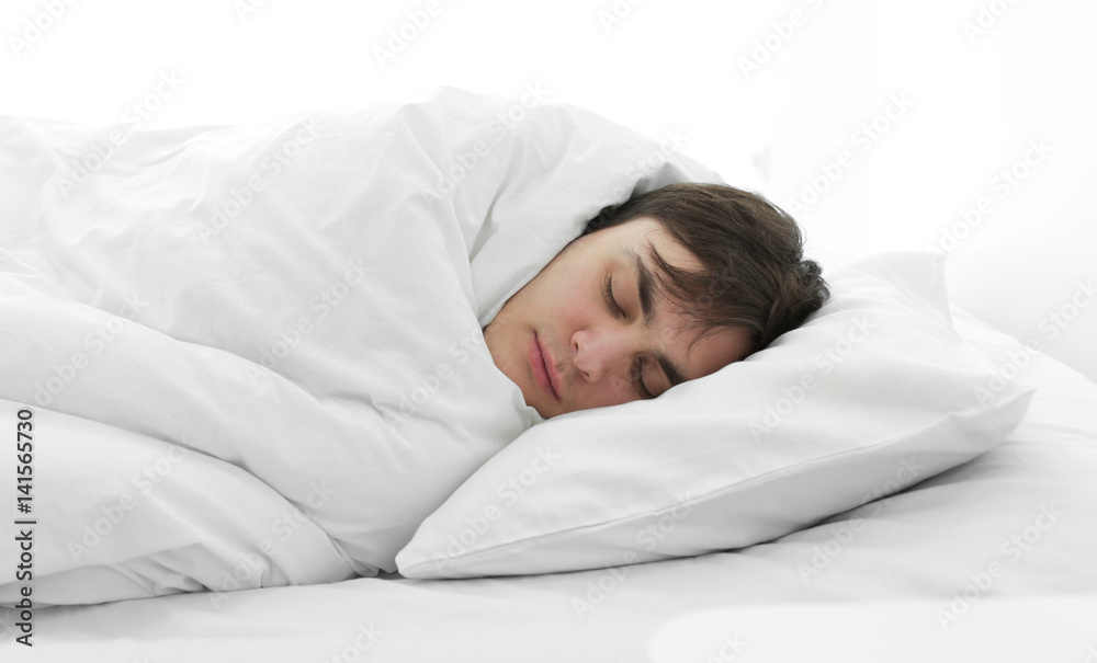 疲惫的年轻人睡在家里的床上