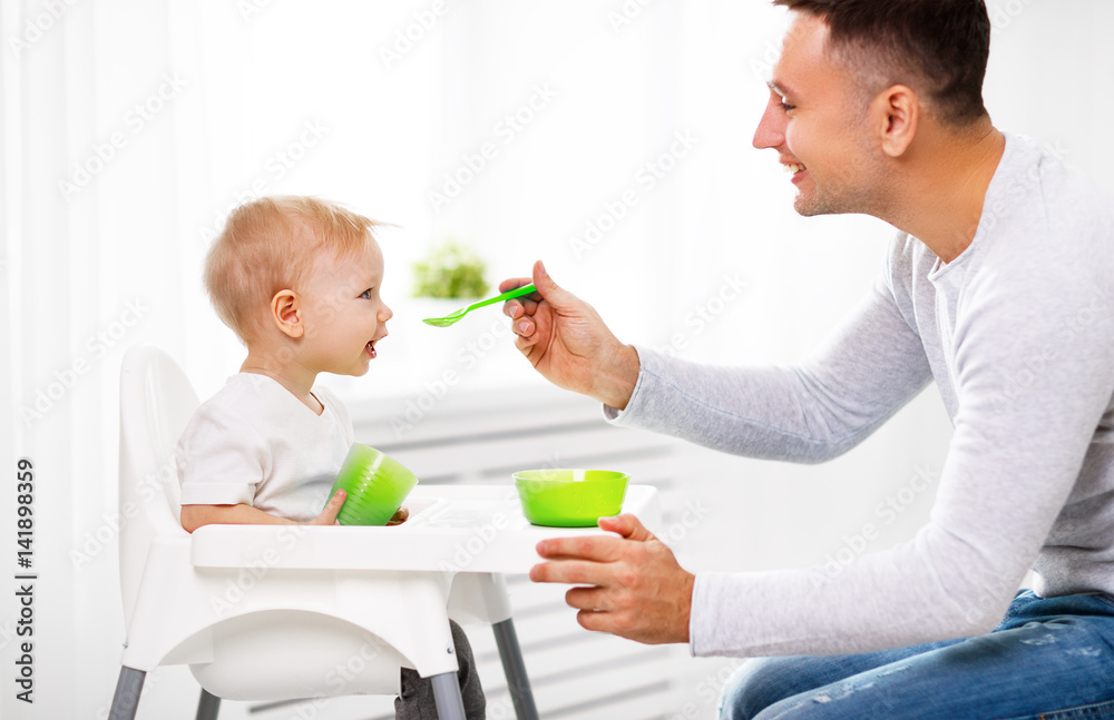 father feeds baby from spoon