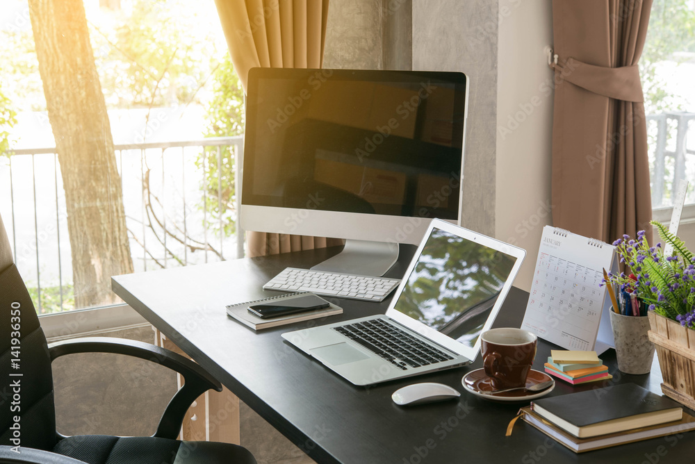 办公桌由笔记本电脑、台式书和咖啡杯组成