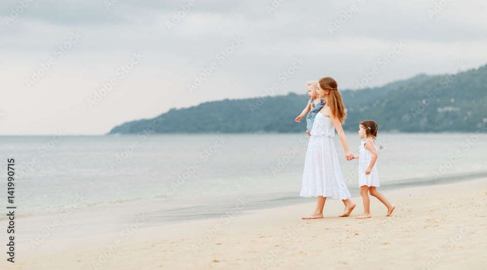 快乐的家庭母亲和孩子在夏天海边的海滩上