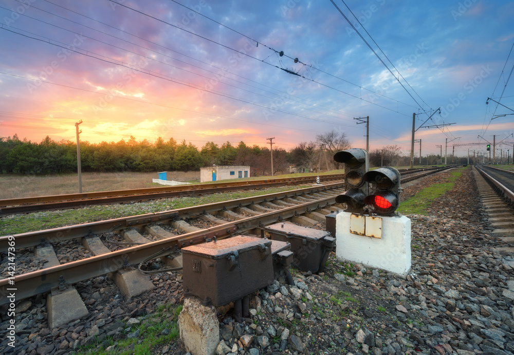 Railway station with semaphore and beautiful bright cloudy sky at sunset. Colorful industrial landsc