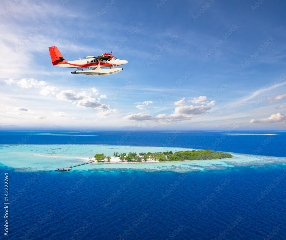 海上飞机在马尔代夫热带小岛上空飞行