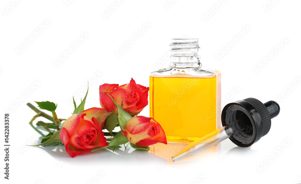 白色背景上有香水油和玫瑰花蕾的瓶子