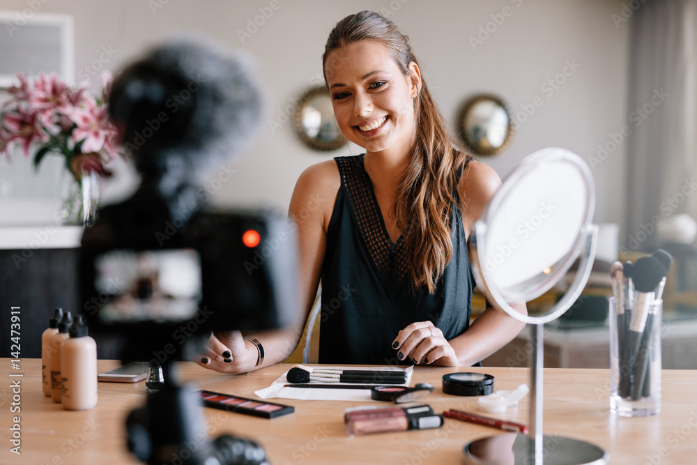 Female blogger recording video for her vlog on beauty and fashio