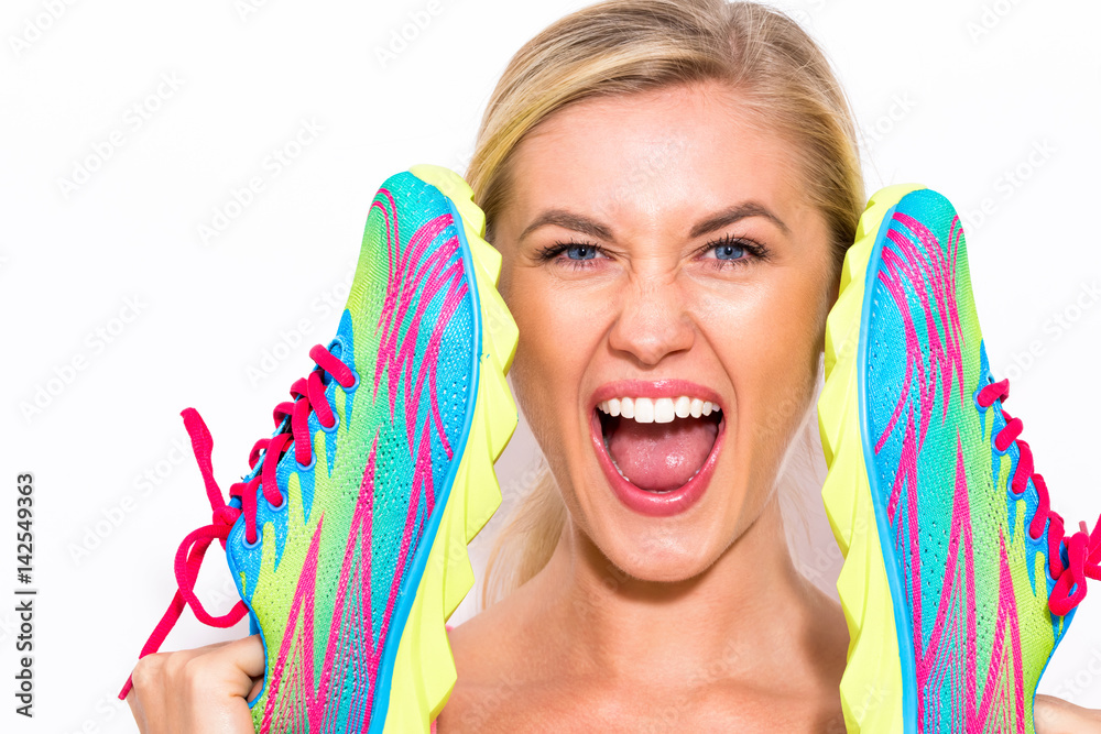 Happy young woman holding shoes