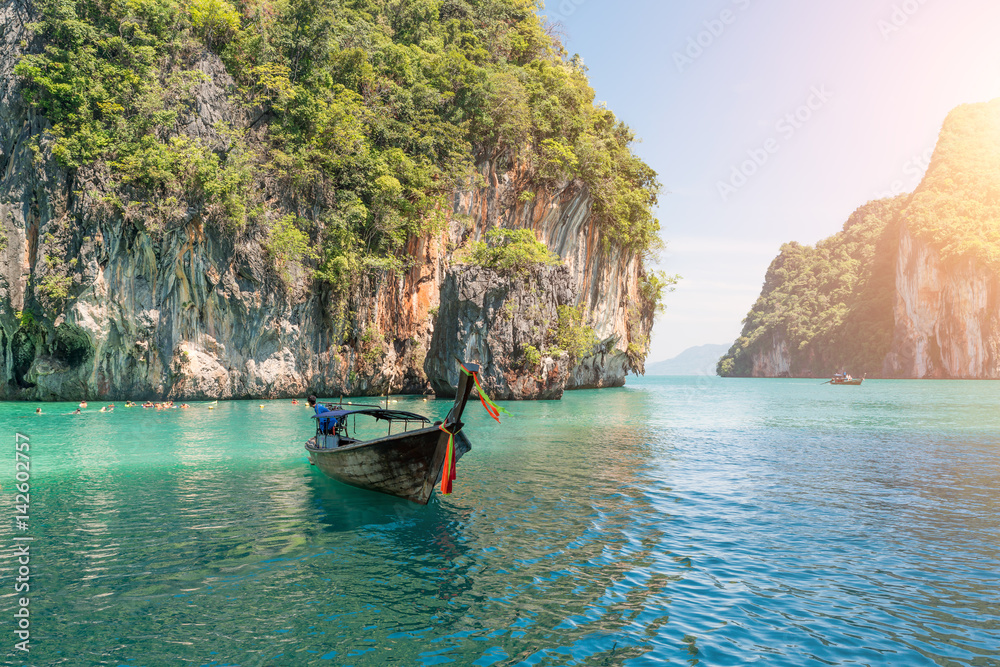 Beautiful landscape of rocks mountain and crystal clear sea with longtail boat at Phuket, Thailand. 