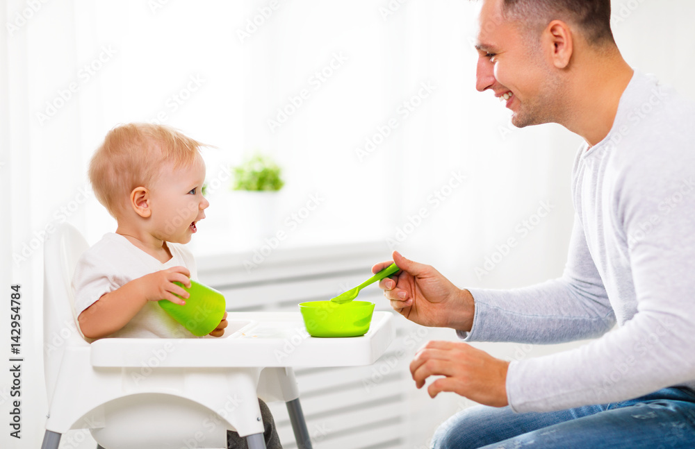 父亲用勺子喂婴儿。