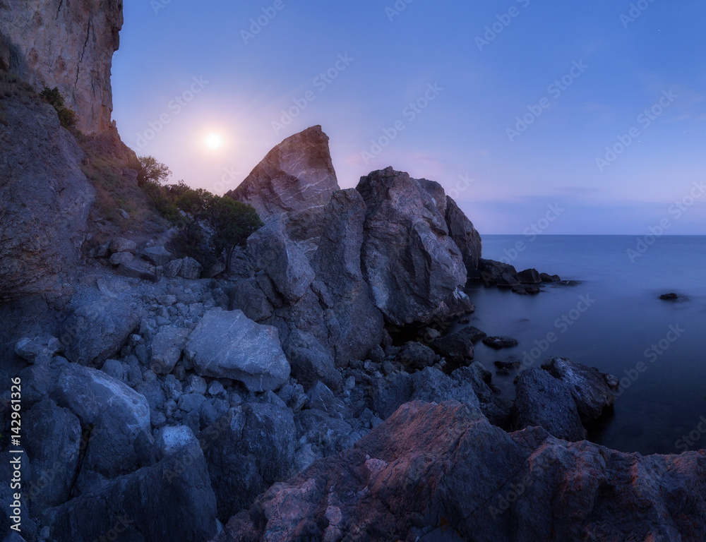 Mountain landscape on the sea at night. High rocks and stones in water on the background of night  b