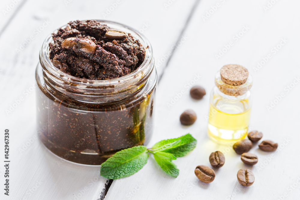 Homemade cosmetics with coffee scrub and oil on white desk background