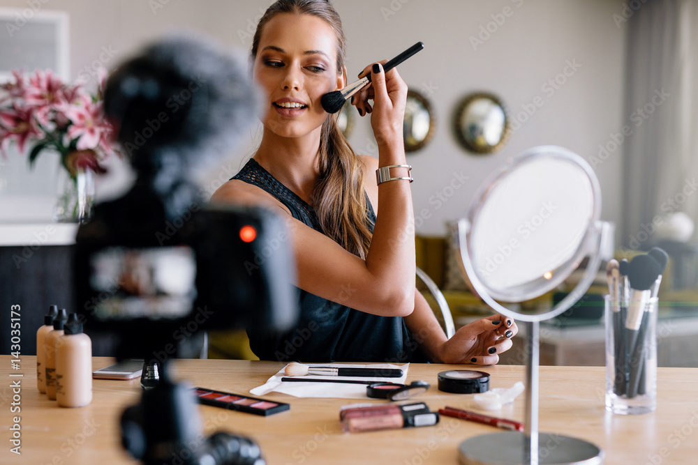 年轻的女性视频记录者正在录制化妆广播。