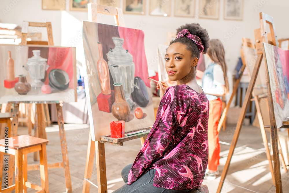一位年轻的非洲学生坐在画室里画静物画的肖像