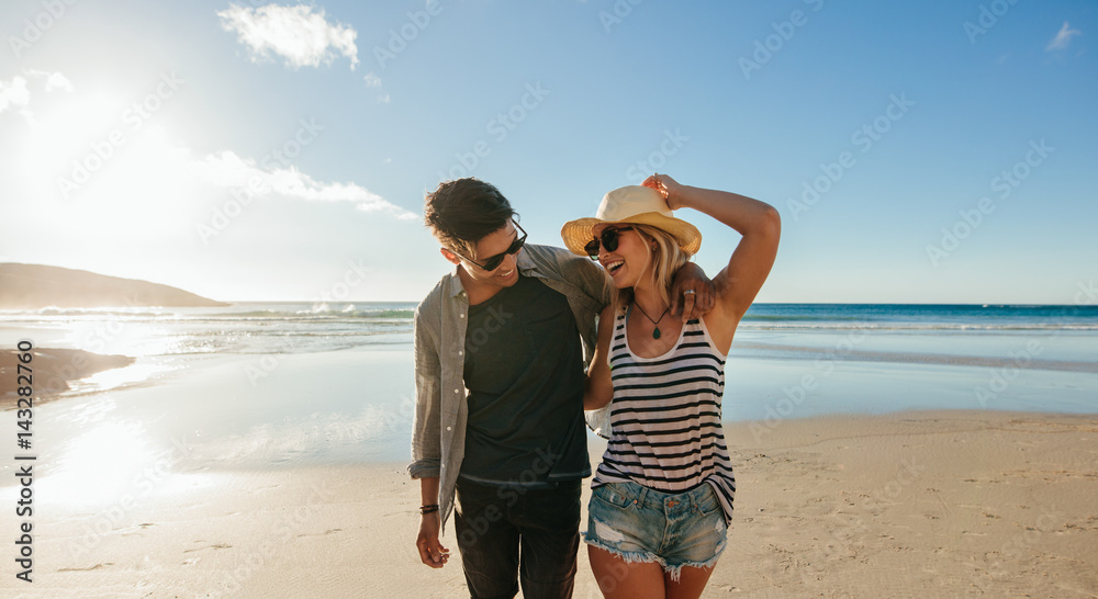 情侣在海边散步大笑