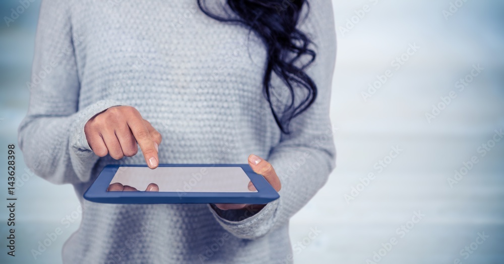女性中段，平板电脑靠着模糊的蓝色木板