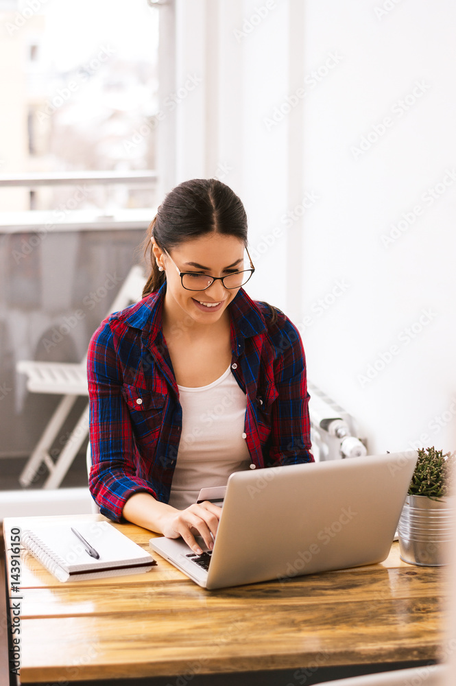 Young woman typing on laptop keyboard at home