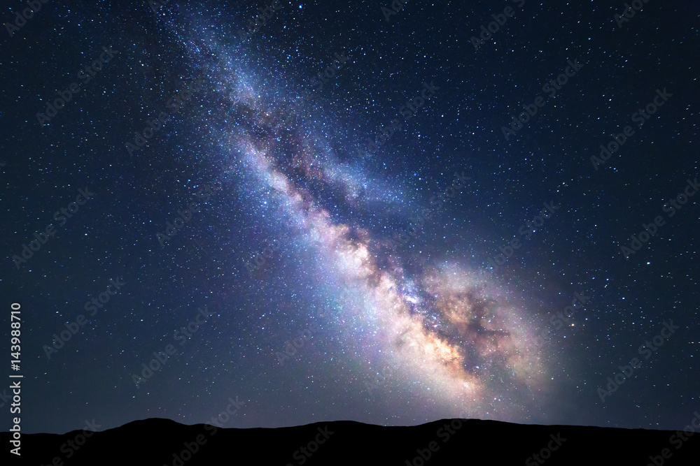 银河系。明亮的银河系、星空和夏季的山丘构成的彩色夜景。太空之旅