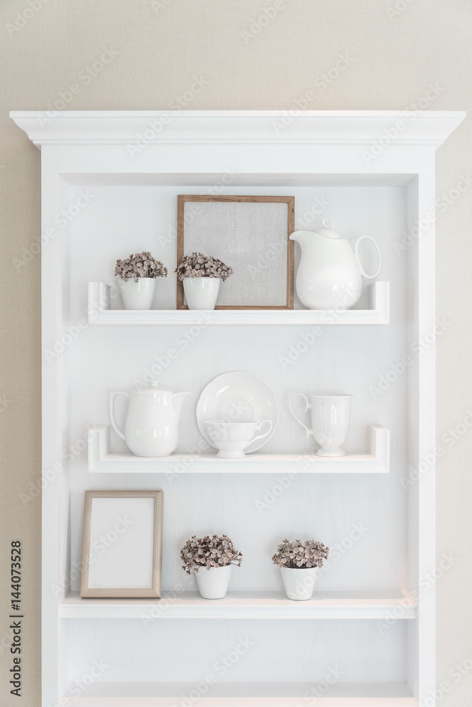 White shelf with vintage porcelain tableware in house.