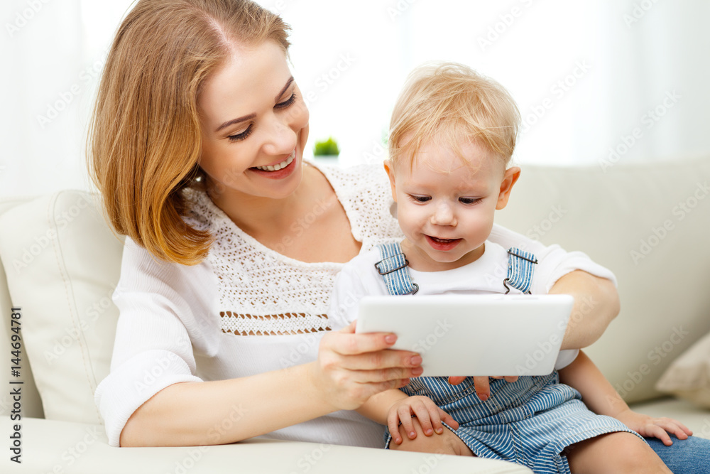 Mother and baby son with a tablet computer at home