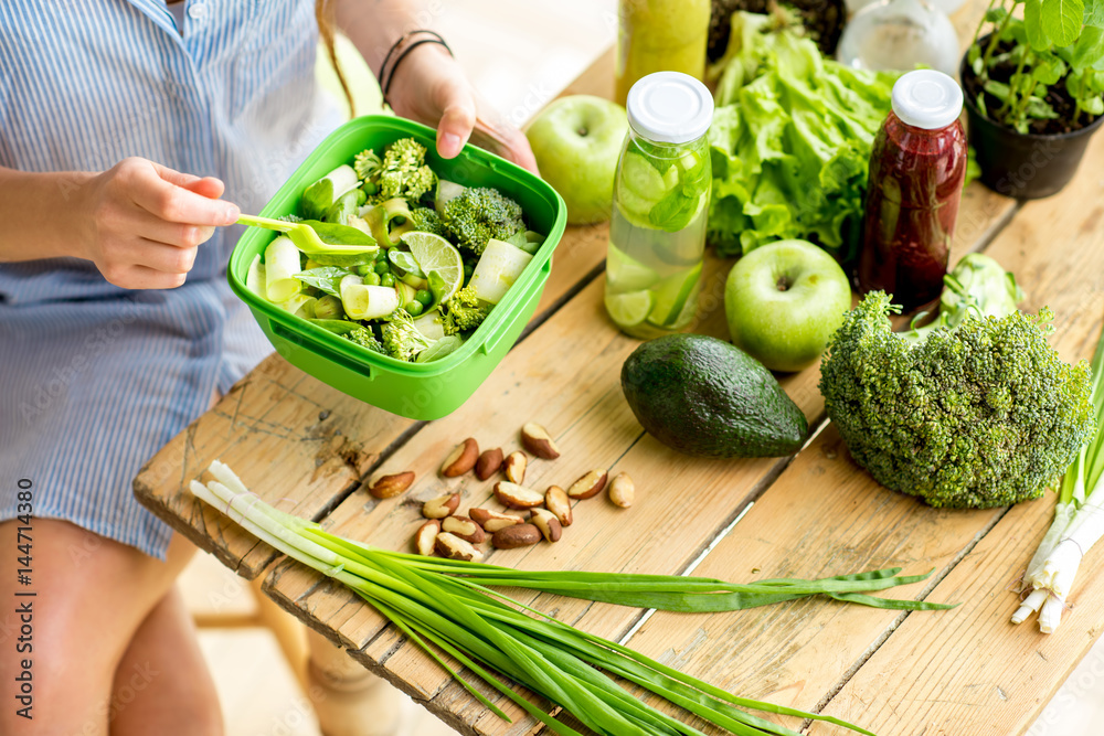 木桌上的碗里放着西红柿和奶酪沙拉，配绿色健康食材。Healt