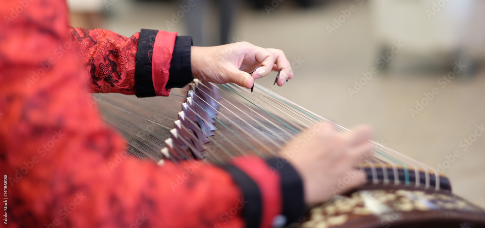 演奏古筝的人的手。古筝或古筝，也简称为筝，是一种中国乐器