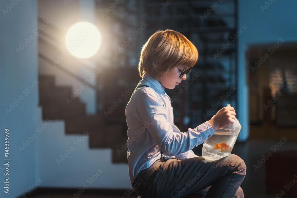 Boy with goldfish in a public plaсe