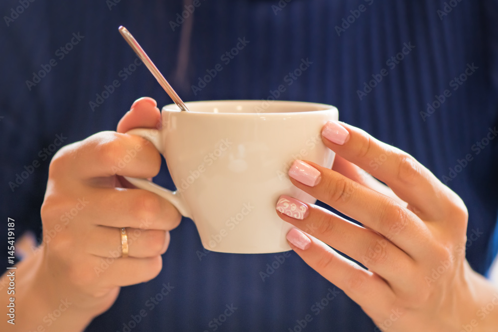 Девушка с красивыми ногтями держит кружку с кофе. Девушка пьет кофе