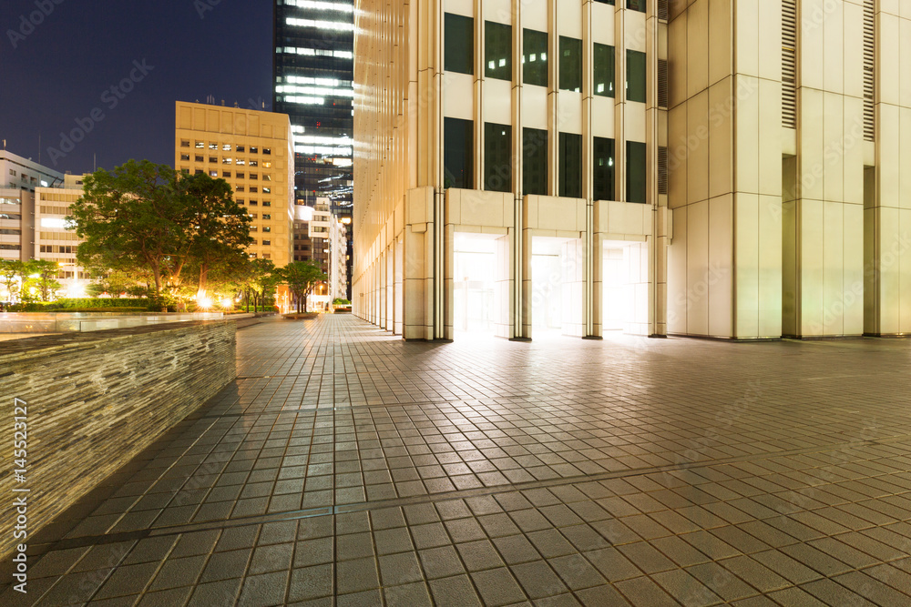 empty footpath outside of modern building at night