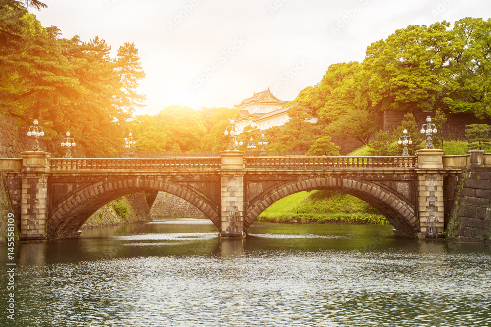 old stone bridge near japanese traditional building with sunbeam