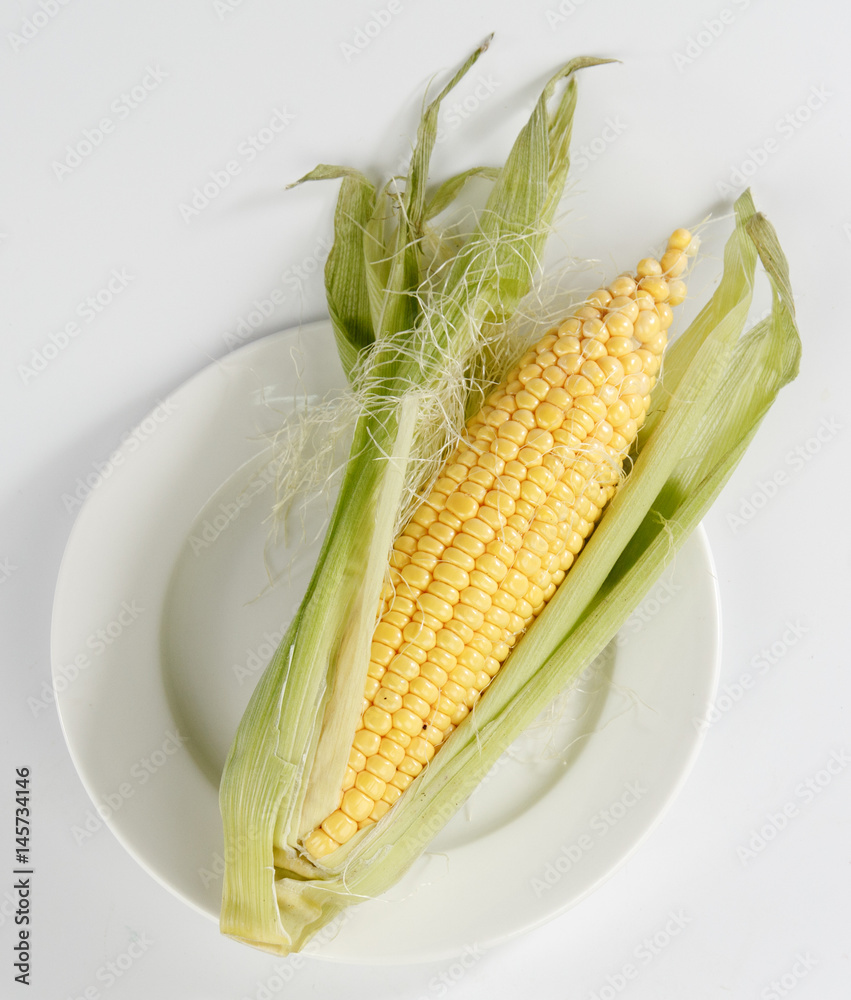 白色背景下分离的盘子里的玉米