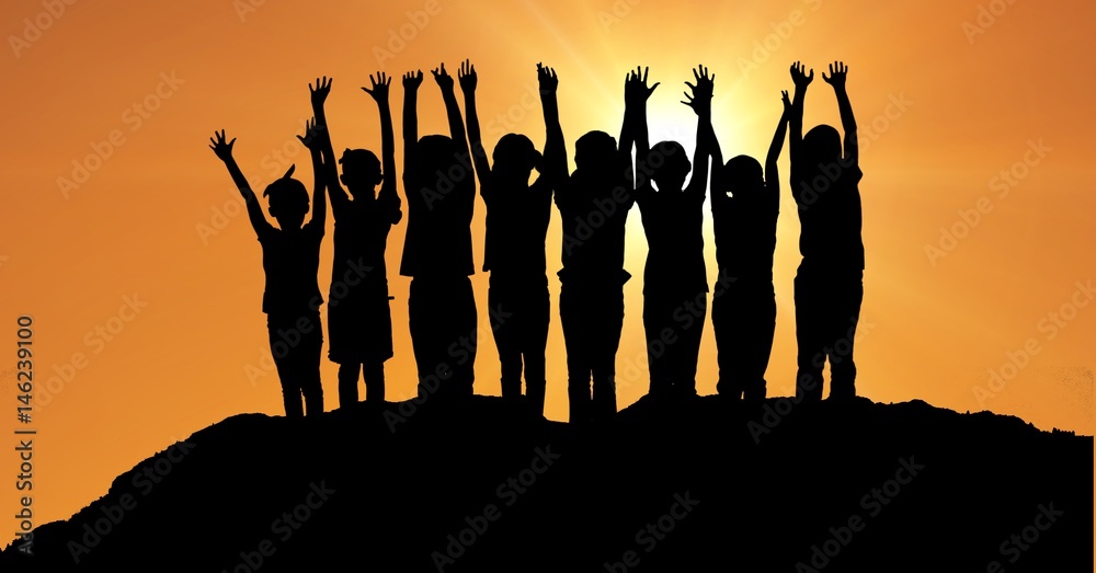 在橙色天空的映衬下，孩子们在山上举起双手的剪影