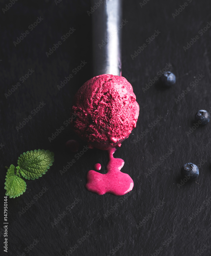 融化的蓝莓冰淇淋勺，黑色板岩背景，选择性聚焦，垂直果盘