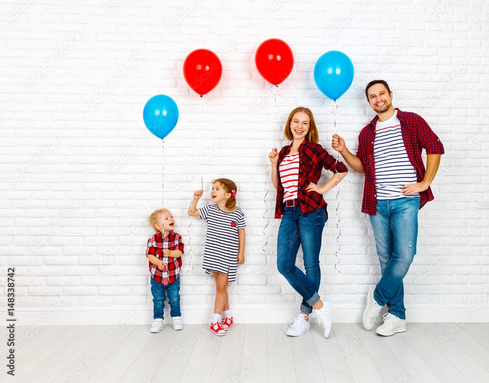 有气球的幸福家庭。白色空白墙上的母亲、父亲、儿子、女儿
