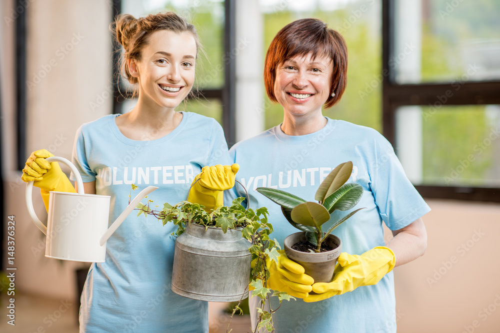 穿着蓝色t恤的中老年志愿者在室内照料绿色植物