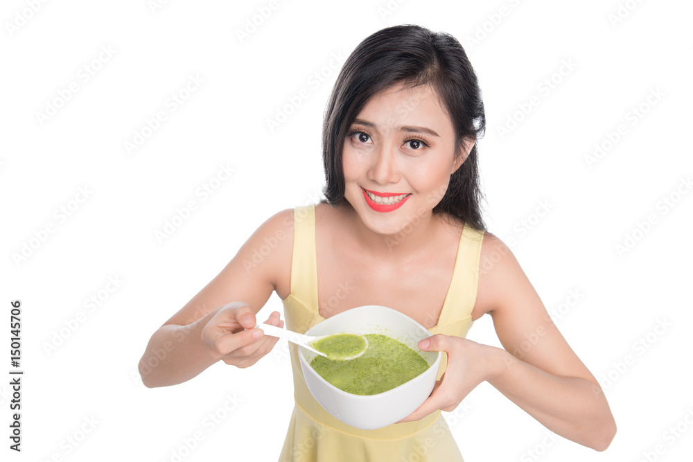 亚洲女人吃/拿着一盘绿色蔬菜汤的画像