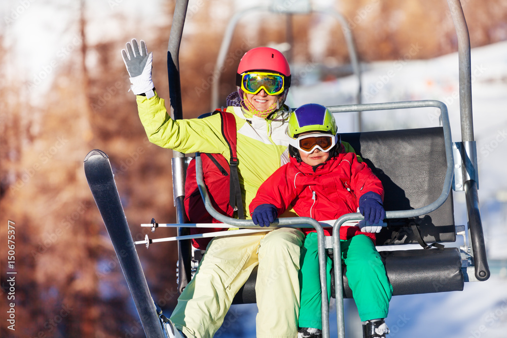 快乐的滑雪者在山上的缆车上举重