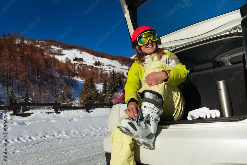 滑雪后脱下滑雪靴的快乐年轻女子