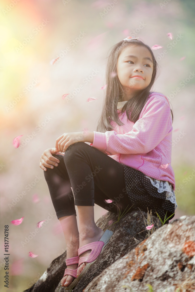 Asian girl sit and relax with Sakura fall