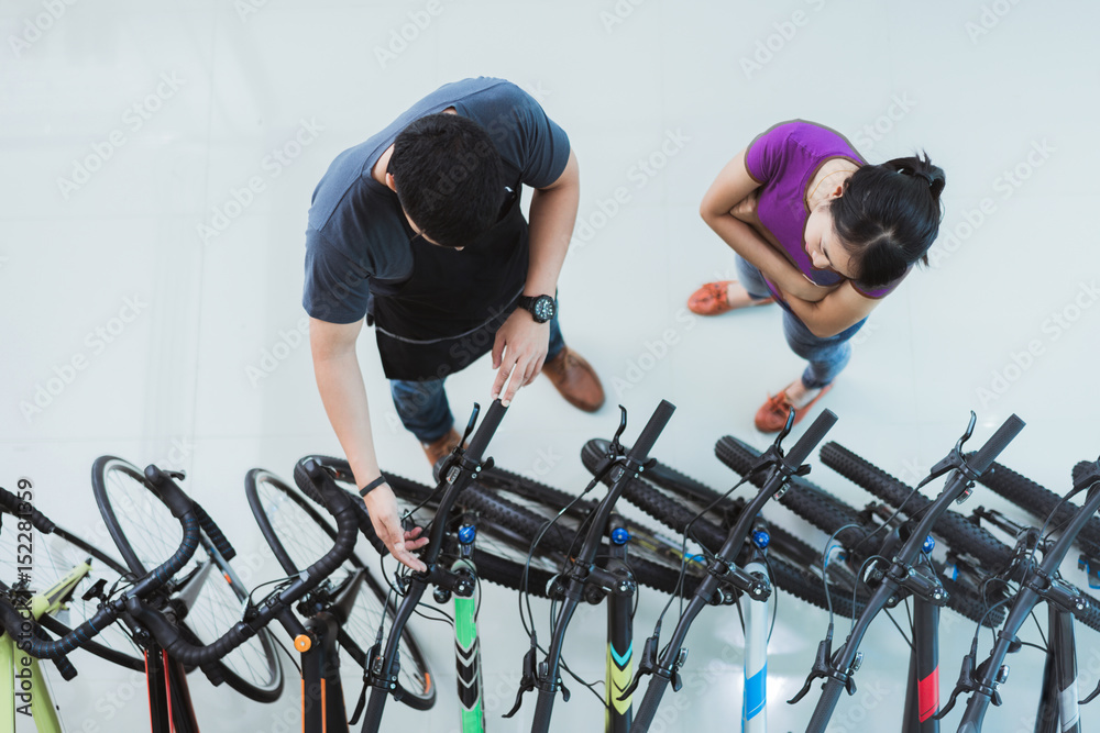 自行车推销员帮助顾客在商店购买自行车。顶部视图