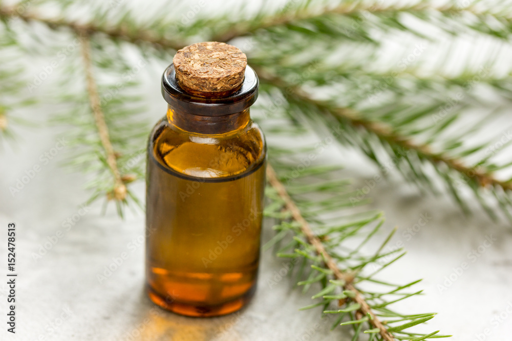 cosmetic spruce oil in bottles with fur branches on white table background