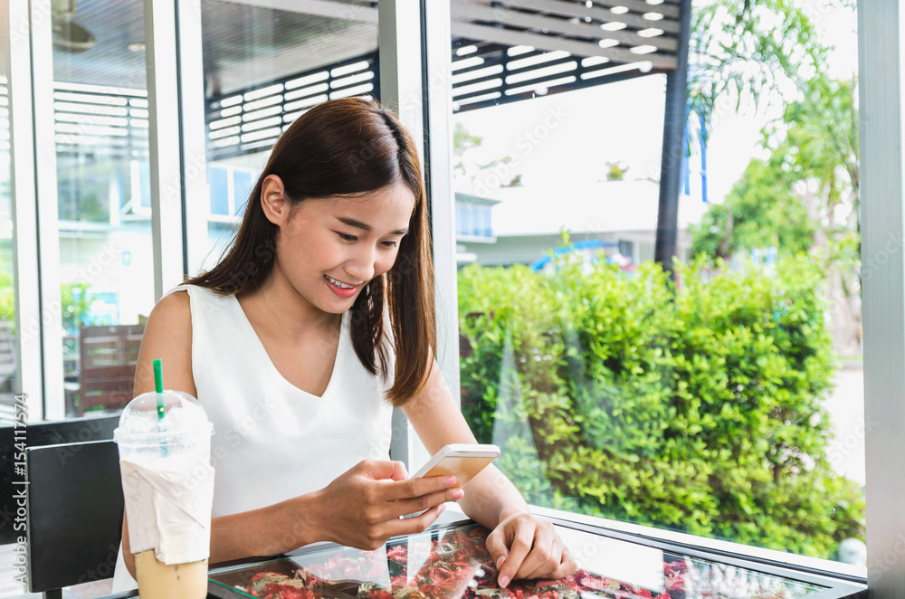 女性在咖啡店使用电话在线购物