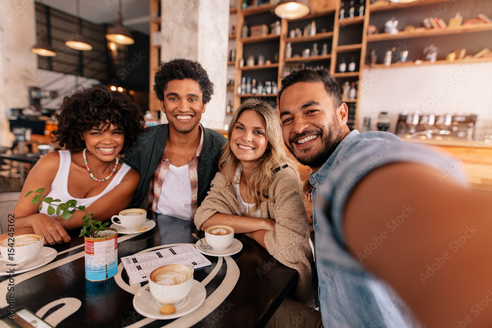 快乐的年轻人在咖啡馆与朋友自拍