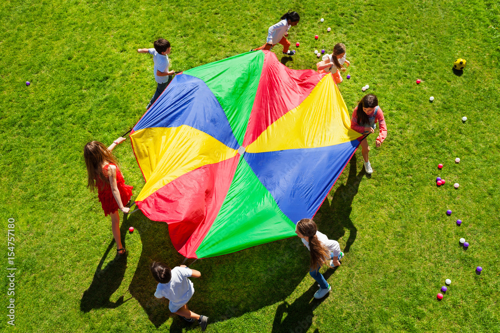 孩子们带着明亮的降落伞围成一圈